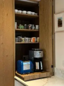 Bespoke bi-fold coffee station with oak cabinetry, integrated storage and quartz worktops